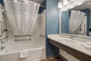 a bathroom with a sink and a shower at WoodSpring Suites Cleveland North in Cleveland +11 photos