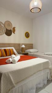 a bedroom with two beds with towels on them at Pousada Mar da Vila in Cabo Frio