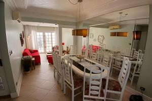 a dining room with a table and white chairs at SHB - Beach House with Air Conditioning in Santos
