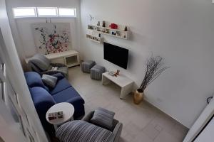 a living room with a blue couch and a tv at SHB - Beach House with Air Conditioning in Santos