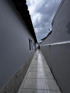 an empty alley with a white wall and a building at Casa de praia in Mongaguá