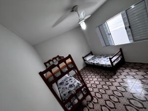 a room with two bunk beds and a window at Casa de praia in Mongaguá