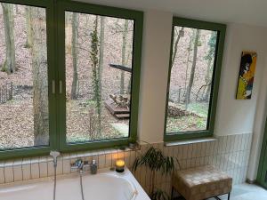 a bathroom with two windows and a bath tub at Mesebeli ház in Kismaros