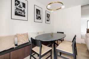 a dining room with a table and chairs and a couch at Casa Blanc - Coastal Triplex in Blankenberge