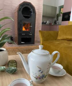 a tea pot on a table in front of a fireplace at Mesebeli ház in Kismaros