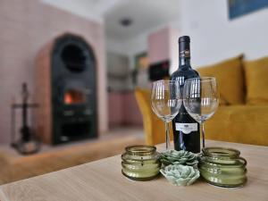 a bottle of wine and two glasses on a table at Mesebeli ház in Kismaros +22 photos