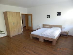 a bedroom with a white bed and a wooden floor at Apartmány Opletalka in Poděbrady