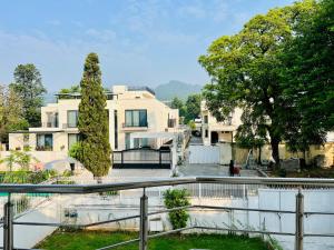 a white house with a fence in front of it at Grand Residency Guest House in Islamabad