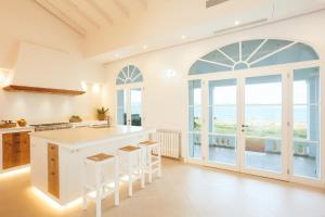 a kitchen with an island and a large window at Veles Dos, villa con piscina frente al mar in Alcudia
