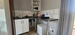 a small kitchen with white cabinets and a counter top at Acacia at Greenway Woods in White River