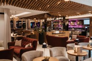 a restaurant with chairs and tables and a bar at Hotel Neubergerhof in Filzmoos