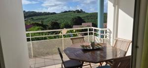 a table and chairs on a balcony with a view at Au zamana in Le Robert