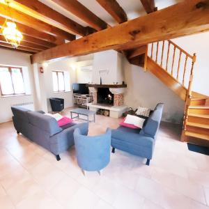 a living room with two couches and a fireplace at Gite De l'Augereau in Céré-la-Ronde