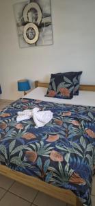 a bed with two towels and a fan on it at Au zamana in Le Robert