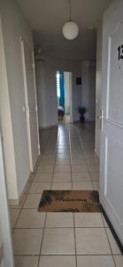 a hallway with a door and a mat on the floor at Au zamana in Le Robert