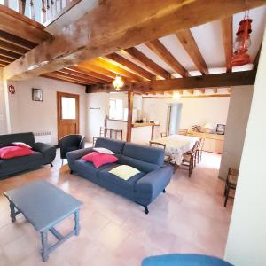 a living room with a blue couch and a table at Gite De l'Augereau in Céré-la-Ronde