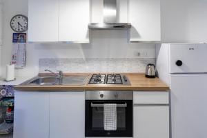 a white kitchen with a stove and a sink at Casa Cesari in Ponte Ronca