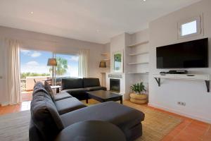 a living room with a couch and a tv at Can Panorama in Talamanca