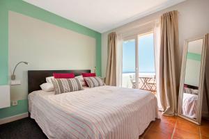 a bedroom with a bed with a view of the ocean at Can Panorama in Talamanca +21 photos