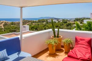 a balcony with two potted plants and a couch at Can Panorama in Talamanca