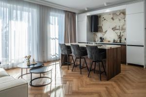 a kitchen with a bar with stools and a table at Smarald Apartment in Satu Mare