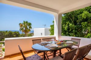 uma sala de jantar com uma mesa e cadeiras numa varanda em Can Panorama em Talamanca