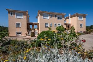 a large house with flowers in front of it at Koralia's Villas in Chorafakia