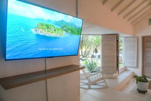 a flat screen tv on a wall in a living room at Casa Rosario in Isla Grande