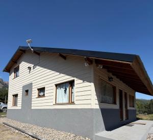a small white house with a black roof at Betsaida2 in Lago Meliquina