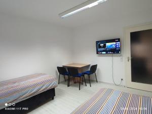 a room with a table and chairs and a flat screen tv at Stadt Apartment Heidenheim in Heidenheim an der Brenz