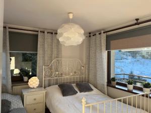 a bedroom with a bed and a large window at Kwatery u Marysi in Szczyrk