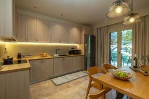 a kitchen with a table and a dining room at Apeiron Villas - Olive Forest Apartment in Kefallonia