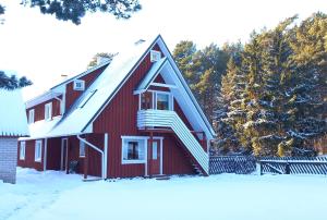 a red barn with a snow covered roof at Lohusalu Studio in Lohusalu +4 photos