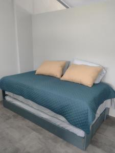 ein Bett mit zwei Kissen darauf in der Unterkunft Marea Place in Carrillo