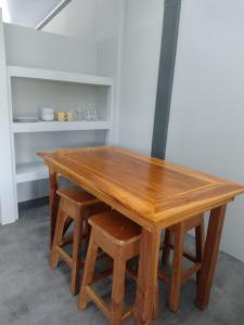 ein Holztisch mit zwei Hockern darum herum in der Unterkunft Marea Place in Carrillo