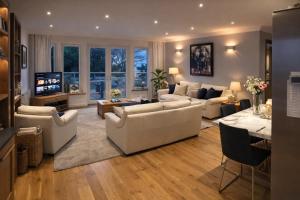 a living room with white couches and a television at Crayford's Guest House in Aberdeen