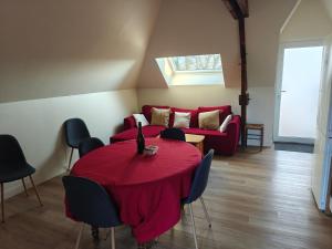 a living room with a table and a red couch at Kerarmel in Ploemeur