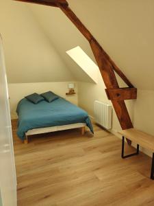 a bedroom with a blue bed in a attic at Kerarmel in Ploemeur
