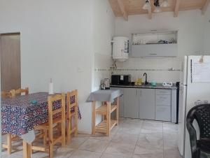 a small kitchen with a table and a refrigerator at Tacuarita in Los Hornillos