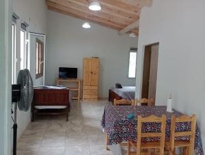 a living room with a table and a bedroom at Tacuarita in Los Hornillos