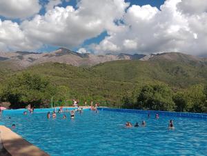 people in a swimming pool with mountains in the background at Tacuarita in Los Hornillos