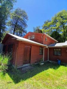 an old red house with trees in the background at Casa Sureña en Ensenada in La Ensenada