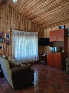 a living room with a couch and a television at Casa Sureña en Ensenada in La Ensenada