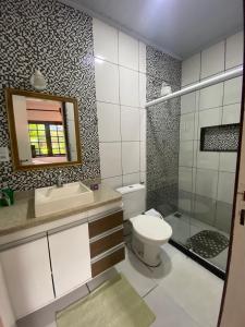 a bathroom with a toilet and a sink and a mirror at LEGATUM POUSADA - Próx a BR 101 e Partage Shopping in Campos dos Goytacazes +35 photos