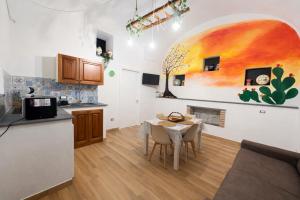 a kitchen and dining room with a table and a painting on the wall at Il Casale del 900 in Catania