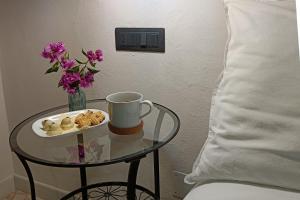 a table with a cup of coffee and a plate of pastries at SUVAJ Rooms in Galatro
