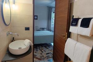a small bathroom with a toilet and a sink at SUVAJ Rooms in Galatro