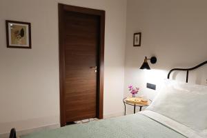 a bedroom with a bed and a wooden door at SUVAJ Rooms in Galatro +4 photos