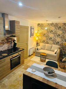 a kitchen and a living room with a couch at Gîte le Nid Dhugava in Hem-Hardinval