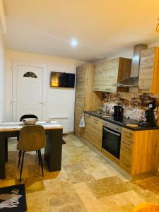 a kitchen with wooden cabinets and a table and a stove at Gîte le Nid Dhugava in Hem-Hardinval +13 photos